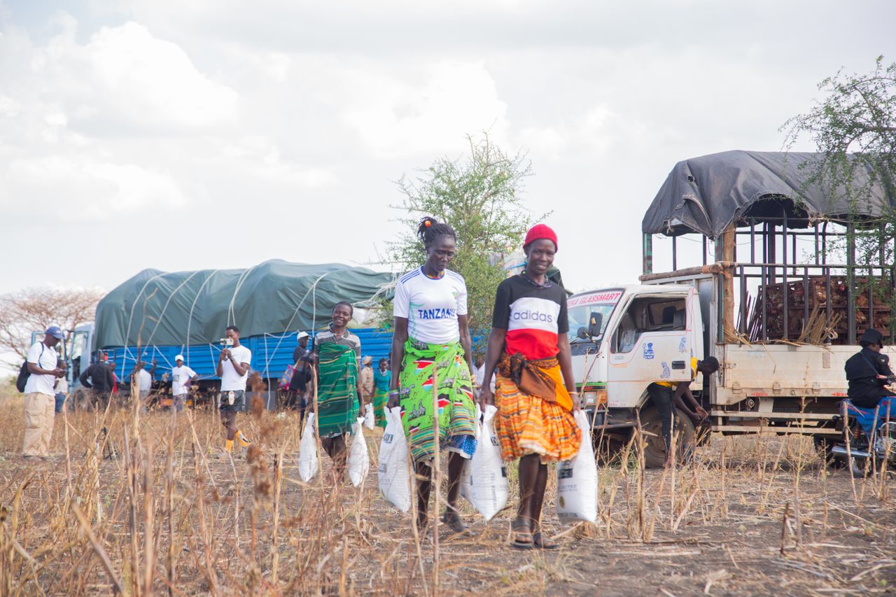 about-us Women participate in a community aid distribution event in a rural setting.